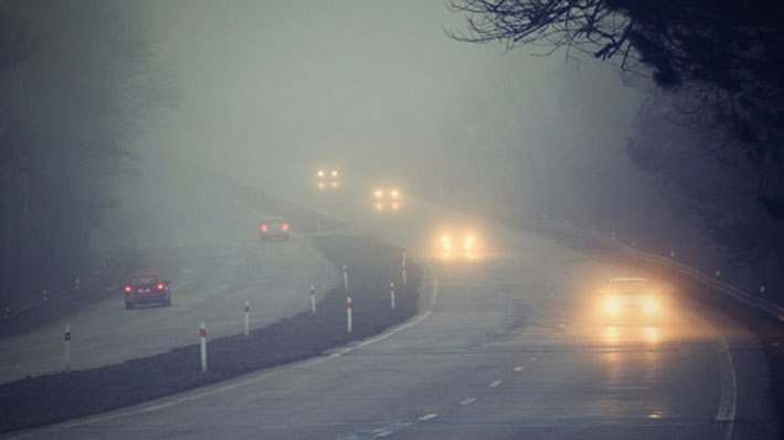 Utilizar luces bajas al manejar un auto por una vía con niebla o neblina